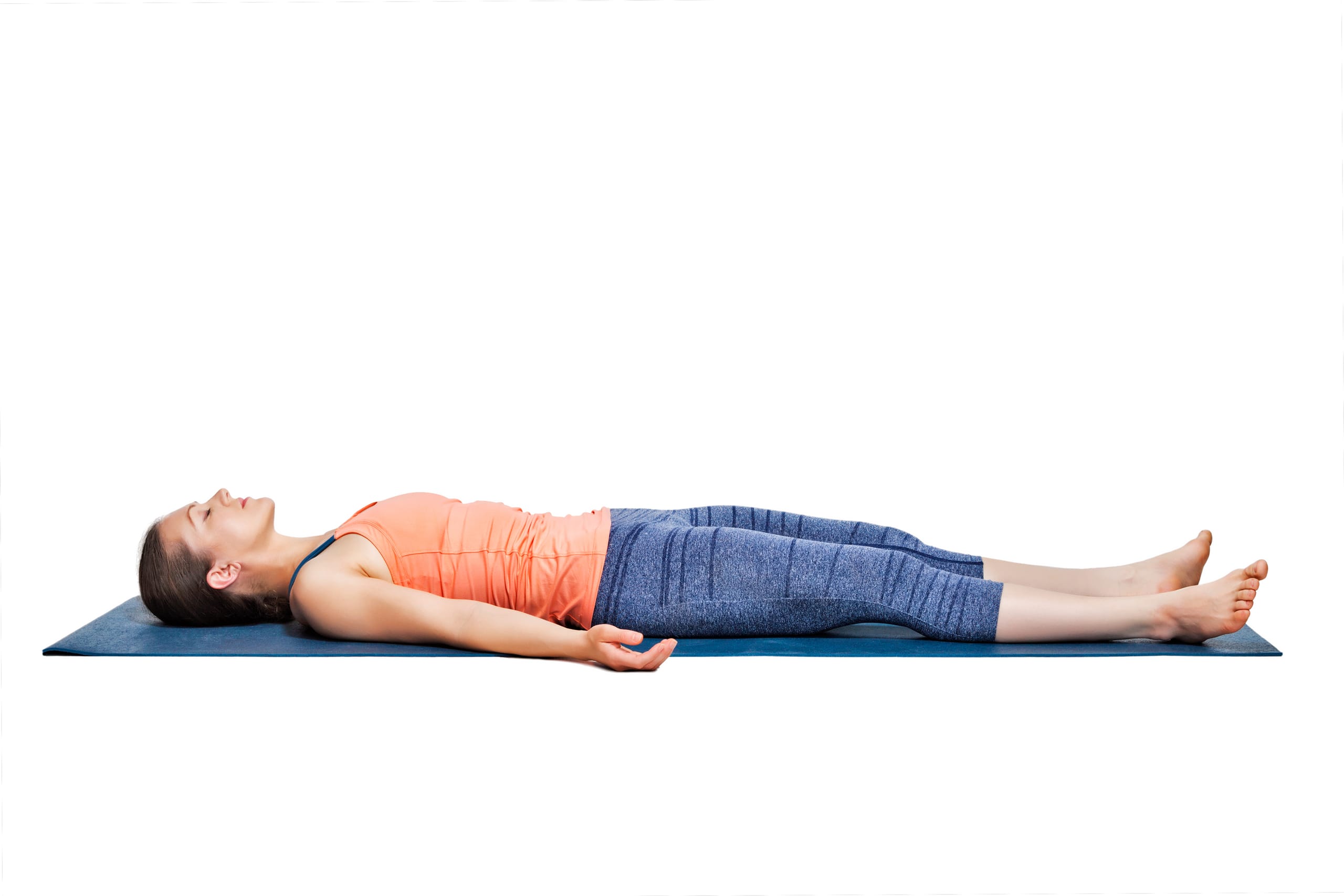 A sporty woman relaxes in yoga savasana - The Corpose Pose
